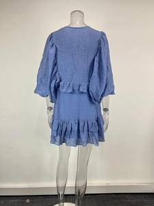 Detailed back view of a blue ruffle dress with bubble sleeves and textured fabric