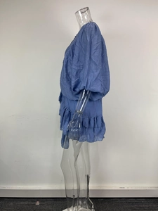 Detail view of purple-blue ruffle dress with puff sleeves and textured fabric