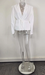 Detailed view of the lapel and waist belt on a white long-sleeve blazer for women