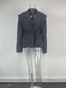 Detail of structured blazer with padded shoulders and drawstring waist on mannequin