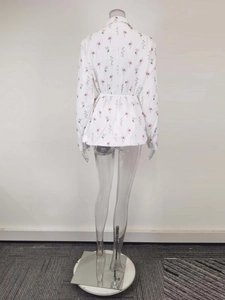 Vue détaillée du dos d'un blazer blanc à fleurs avec une ceinture à nouer ajustable