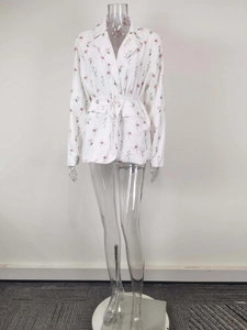 Détail du blazer blanc à fleurs avec imprimé rose et cordon de serrage à la taille