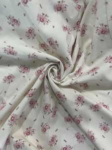 Gros plan sur un tissu en mousseline légère avec imprimé floral rose sur fond crème