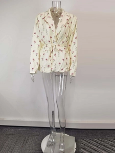 Detail of floral print blazer featuring notched lapels and adjustable waist drawstring