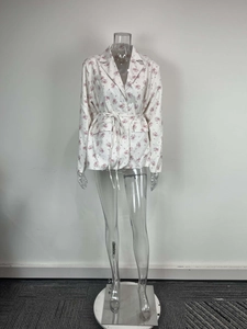 Détail de la veste blazer fleurie avec col à revers et ceinture nouée à la taille