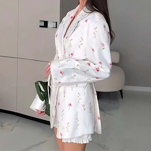 Detail of floral blazer set with ruffles and feminine pink flower patterns