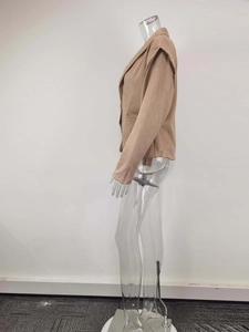 Detailed shoulder view of khaki blazer with structural pads and buttoned epaulette design