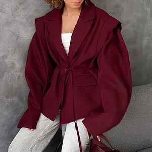 Detail of burgundy blazer featuring trench-style shoulder flaps and waist tie closure