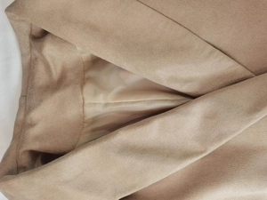 Macro detail of khaki suede jacket collar showing smooth lining and premium stitching