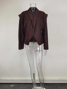 Detailed view of the structured shoulder pads and lapel on a brown suede blazer jacket