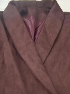 Close-up of elegant burgundy suede blazer showing notched lapels and silk lining detail