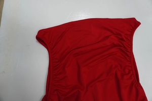 Detailansicht aus rotem Stretchstoff mit engen seitlichen Raffungen und glatter Textur