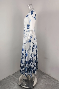 Detail of white V-neck dress with blue floral print and high-waisted A-line skirt
