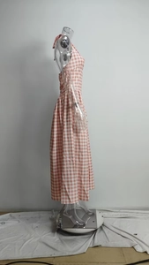 Detailed side view of pink gingham halter dress featuring a low back and pleated waist