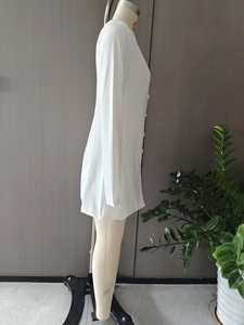 Seitenansicht eines weißen langärmeligen Minikleides mit Knöpfen auf einer Schaufensterpuppe