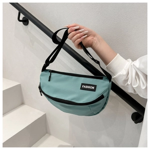 Detail of lake blue crescent messenger bag with fashion logo and adjustable strap