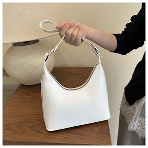 Close-up of white crescent shoulder bag with smooth PU leather and silver metal zipper