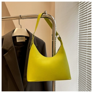 Detail of adjustable silver buckle and lime green synthetic leather strap on a hobo bag