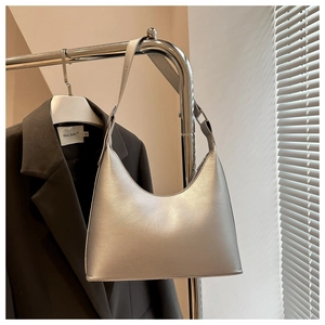 Close-up of silver minimalist crescent underarm bag with adjustable strap and leather texture