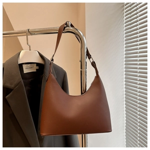 Detail of dark brown matte leather crescent shoulder bag with adjustable strap