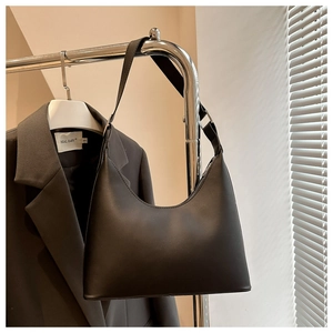 Detail of a black matte PU leather underarm bag with zipper closure and adjustable strap