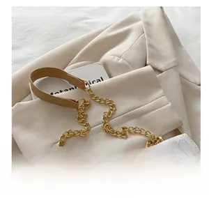 Détail du sac carré chic avec bandoulière en chaîne dorée et motif de papillon