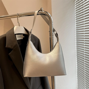 Chic silver metallic hobo underarm bag with minimalist design on a sleek coat hanger