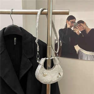 Sac demi-lune argenté avec détails papillons métalliques et bandoulière réglable