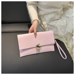 Detailed view of pink pleated clutch bag featuring a gold twisted knot metal clasp closure
