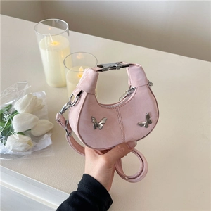 Sac bandoulière rose en forme de lune avec papillons en métal et texture suédée
