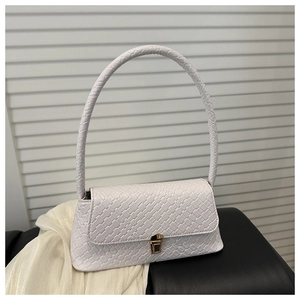 Détail de la texture en cuir tressé blanc et du fermoir doré sur ce sac baguette chic