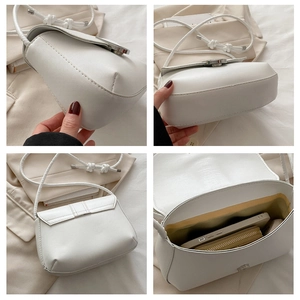Detail view of white minimalist crossbody bag showing internal space and strap texture