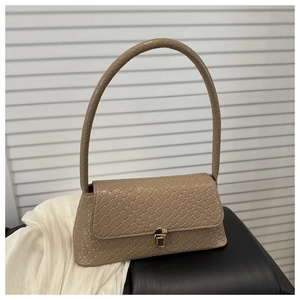 Détail du sac à main marron à texture tressée avec boucle dorée et bandoulière fine