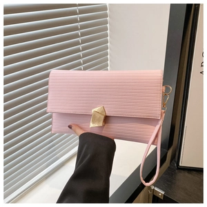 Detailed macro of pink PU leather clutch with fine texture and golden geometric buckle