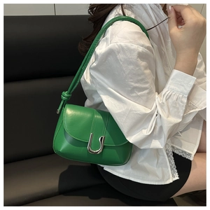 Close-up of bright green leather handbag featuring a U-shaped silver buckle and knotted strap