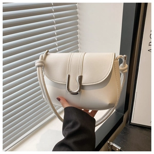 Detail of the white leather shoulder bag featuring a unique knot-design strap and silver U-clasp