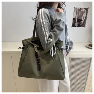 Detail of olive green large tote bag with woven drawstring in minimalist setting