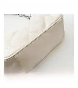 Detail view of cream quilted PU leather texture and silver chain strap for women handbag