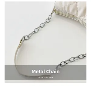 Close-up of the silver metal chain strap and quilted leather texture on the white bag