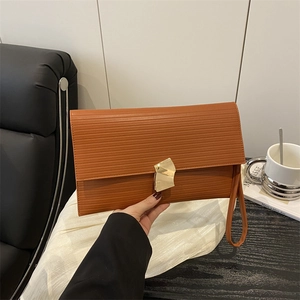 Caramel brown handbag with wave pattern and gold geometric buckle in minimalist style
