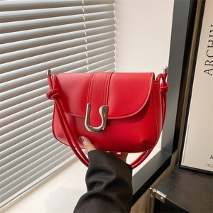 Chic red leather crossbody bag with silver U-shaped metal buckle and knotted strap detail