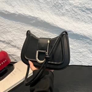Minimalist black crescent saddle bag with gold D-ring buckle and knotted strap detail