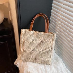 Handwoven straw tote bag with brown handles and V-shaped knit pattern for summer