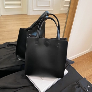 Minimalist black matte leather square tote bag with dual handles and magnetic buckle