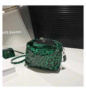 Close-up of green leopard print faux leather bag with glossy finish and silver hardware