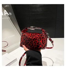 Close-up of red leopard print crossbody bag with glossy finish and silver clasp