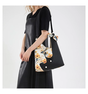 Detail of floral patchwork tote bag with 3D flower petals and black wide strap on model