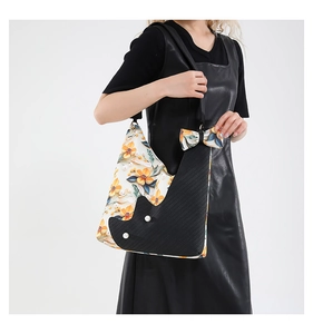 Floral print tote bag with pearl accents shown on a model in a black leather dress