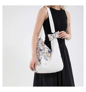 Close-up of floral tote bag featuring white pebble leather and pearl embellishments