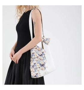 Detail of tulip tote bag featuring white crocodile texture with light blue floral fabric
